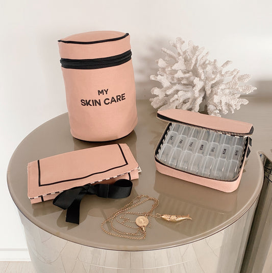 Bag-all Essential Gift Set Deal 3-Pack in Pink: Round Skincare Case, Pill Organizer, and Jewelry Roll Pouch displayed on gray surface with decorative coral, premium cotton organizers in blush pink