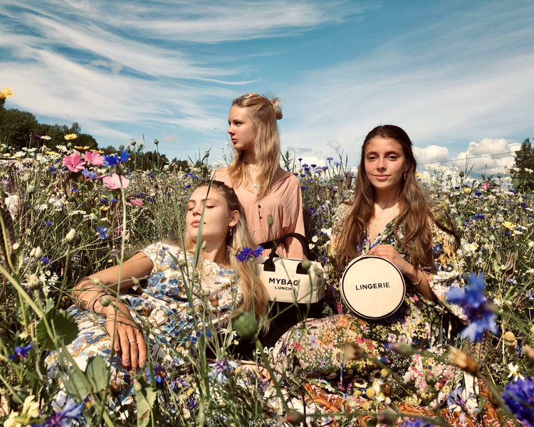 three girls sitting on a field with bag-all products