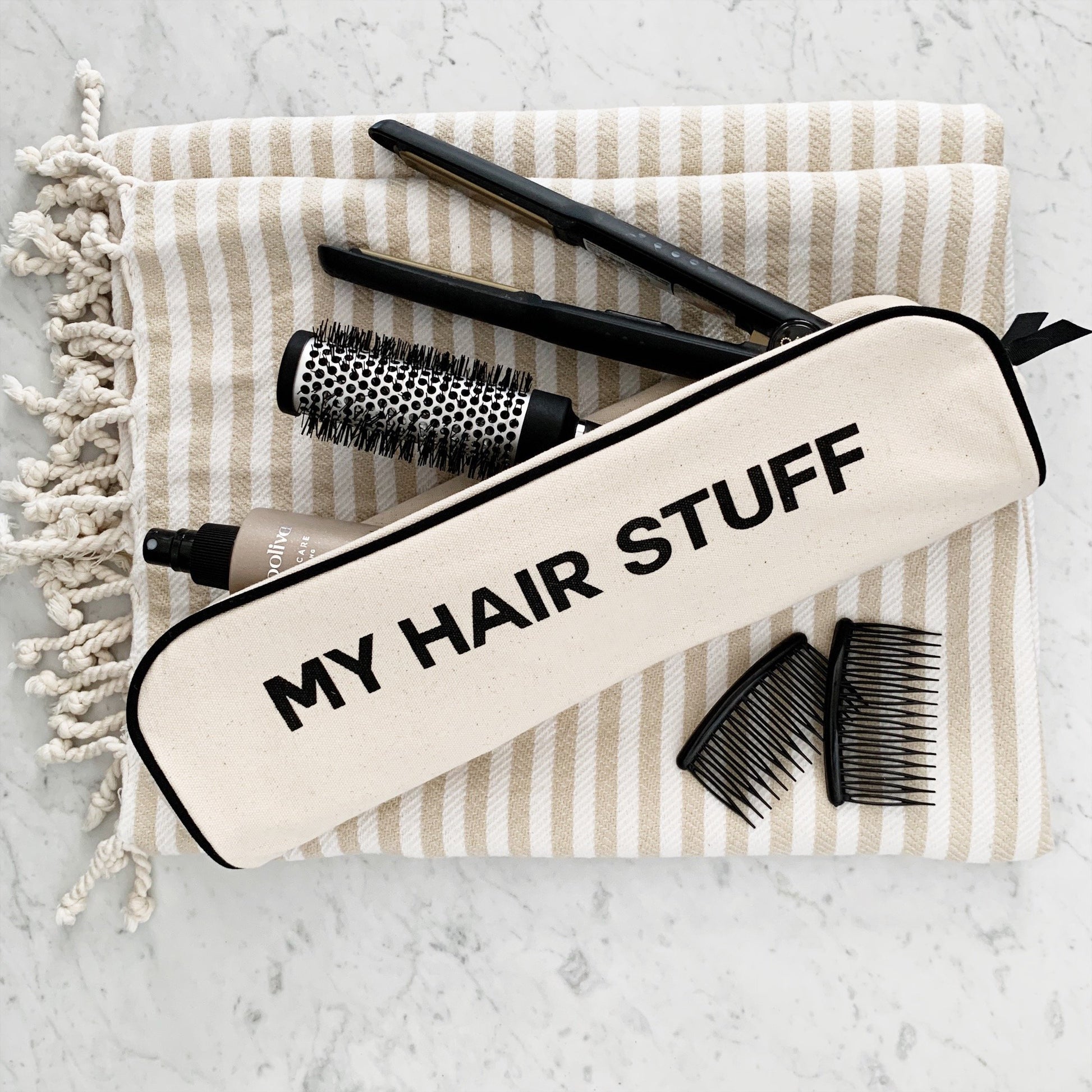 Cream Bag-all hair organizer pouch with black trim and MY HAIR STUFF text styled with combs brush and flat iron on striped towel