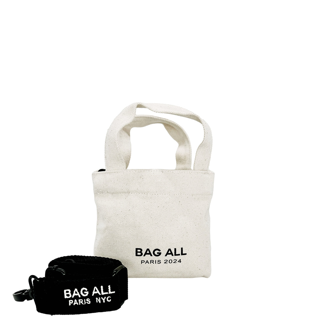 Bag-all Mini Tote Bag in cream cotton with adjustable strap, interior pocket, and classic Bag-all branding. Eco-friendly canvas tote shown with black accessory pouch.
