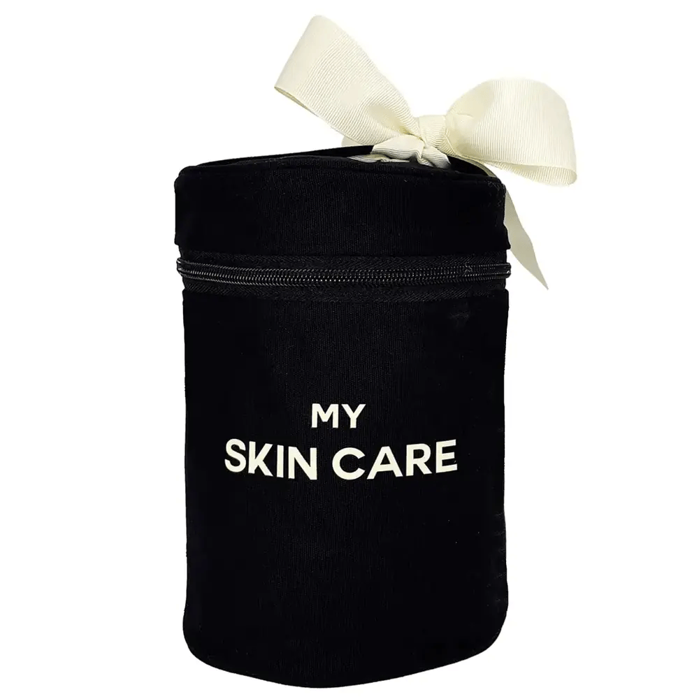 Bag-all Round Skin Care Case with Handle in black cotton featuring cream bow, white text "MY SKIN CARE", laminated interior with organizing pockets for beauty products