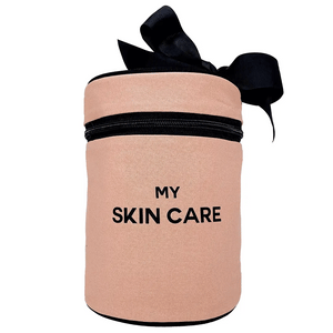 Bag-all Round Skin Care Case with Handle in blush pink featuring black text, zipper closure, and decorative bow - stylish cylindrical organizer for beauty products