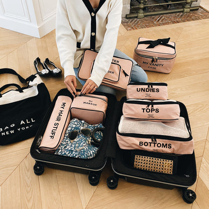 Bag-all Cotton Packing Cubes in Pink/Blush, 3-piece set shown in open suitcase with organized travel essentials and matching vanity cases, demonstrating size variety and practical storage solution