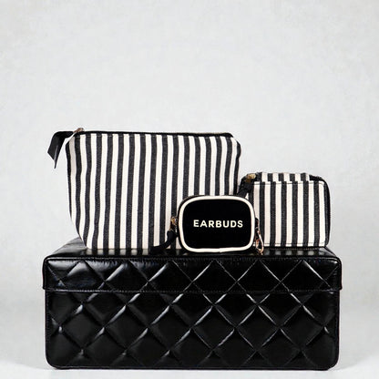 Set of Bag-all striped handbag organizers featuring trinket, makeup, and earbuds cases on black quilted box background