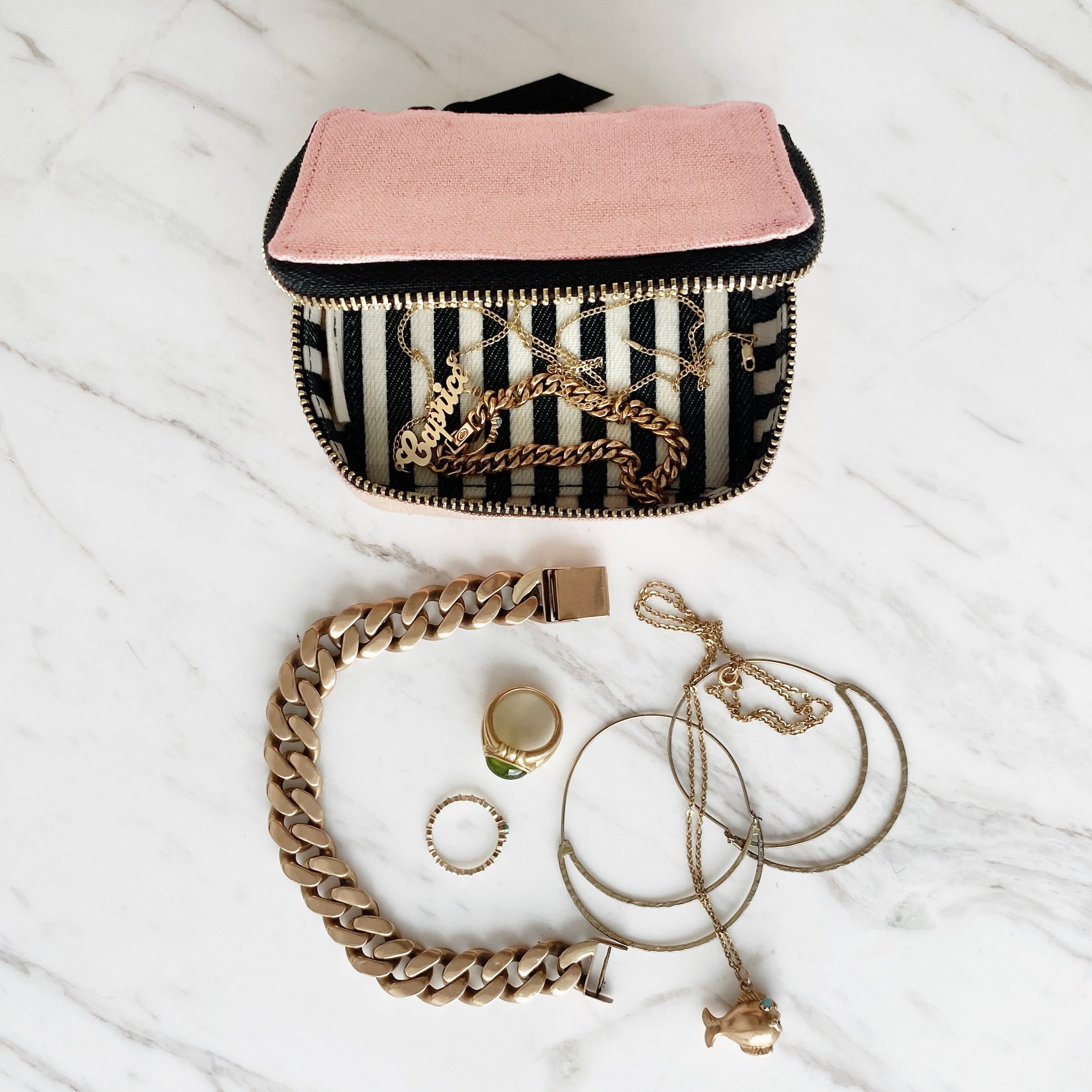 Bag-all pink blush trinket organizer with gold jewelry on white marble for stylish travel storage