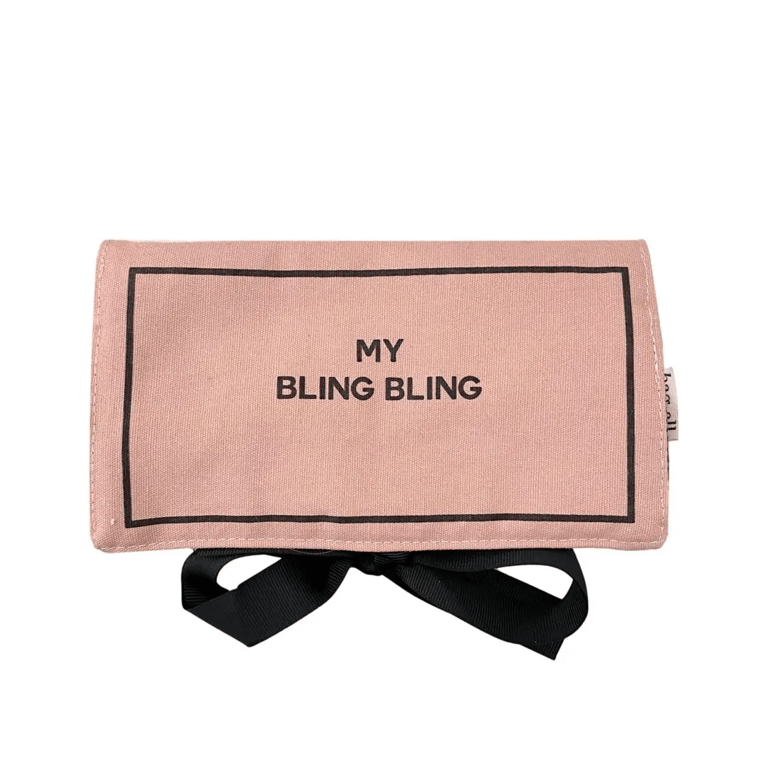 Folded blush pink Bag-all jewelry case with black ribbon tie and My Bling Bling text on white background