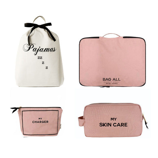 Bag-all Essentials Getaway 4-Pack featuring white pajama bag with black bow, pink packing cube, charger pouch, and skincare case in blush pink with black text labels