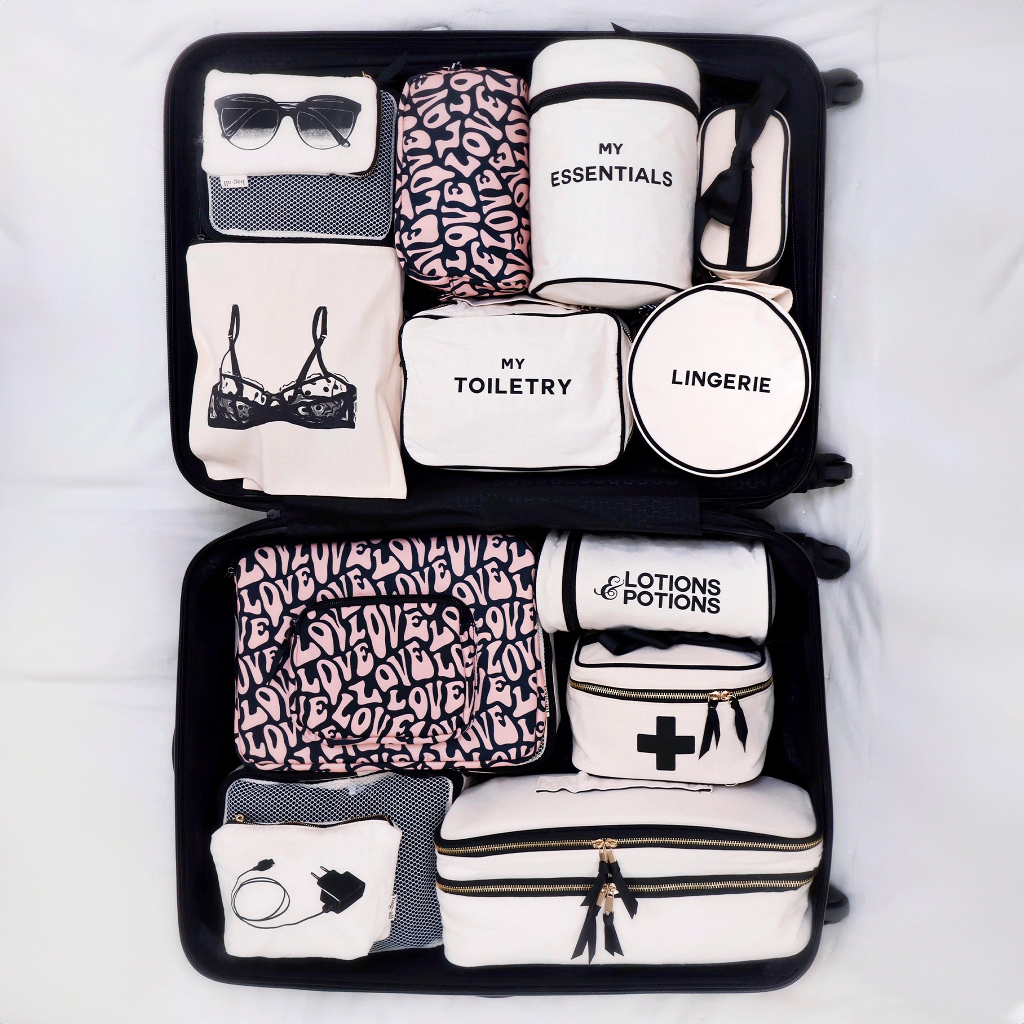 Bag-all Toiletry Pouch with Love Pattern featuring organized compartments for essentials, lingerie, lotions, and accessories in black and white design with pink love pattern details