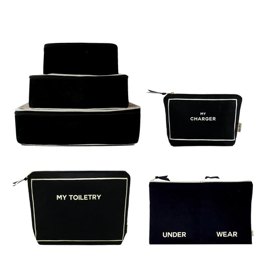 Bag-all Weekend Essential Packing Set 4-Pack in Black featuring stacked cotton organizer cubes, toiletry pouch, charger case, and underwear bag with white trim detail