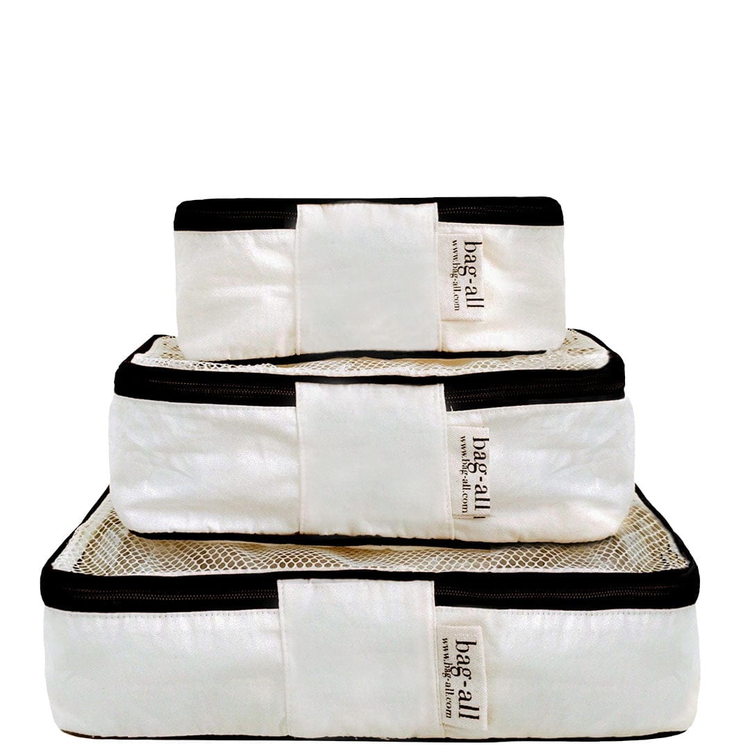 Bag-all Weekend Essential Packing Set 4-Pack in cream featuring three cotton packing cubes with black trim, perfect for organized travel and home storage