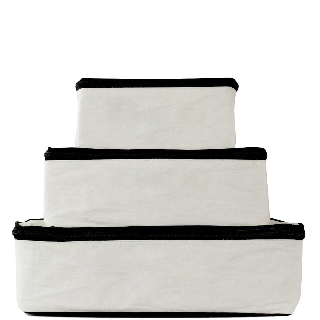Bag-all Travel Glam 4-Pack in cream cotton featuring organizer cubes for clothing, lingerie, makeup and tech accessories, with black trim detail and zipper closures