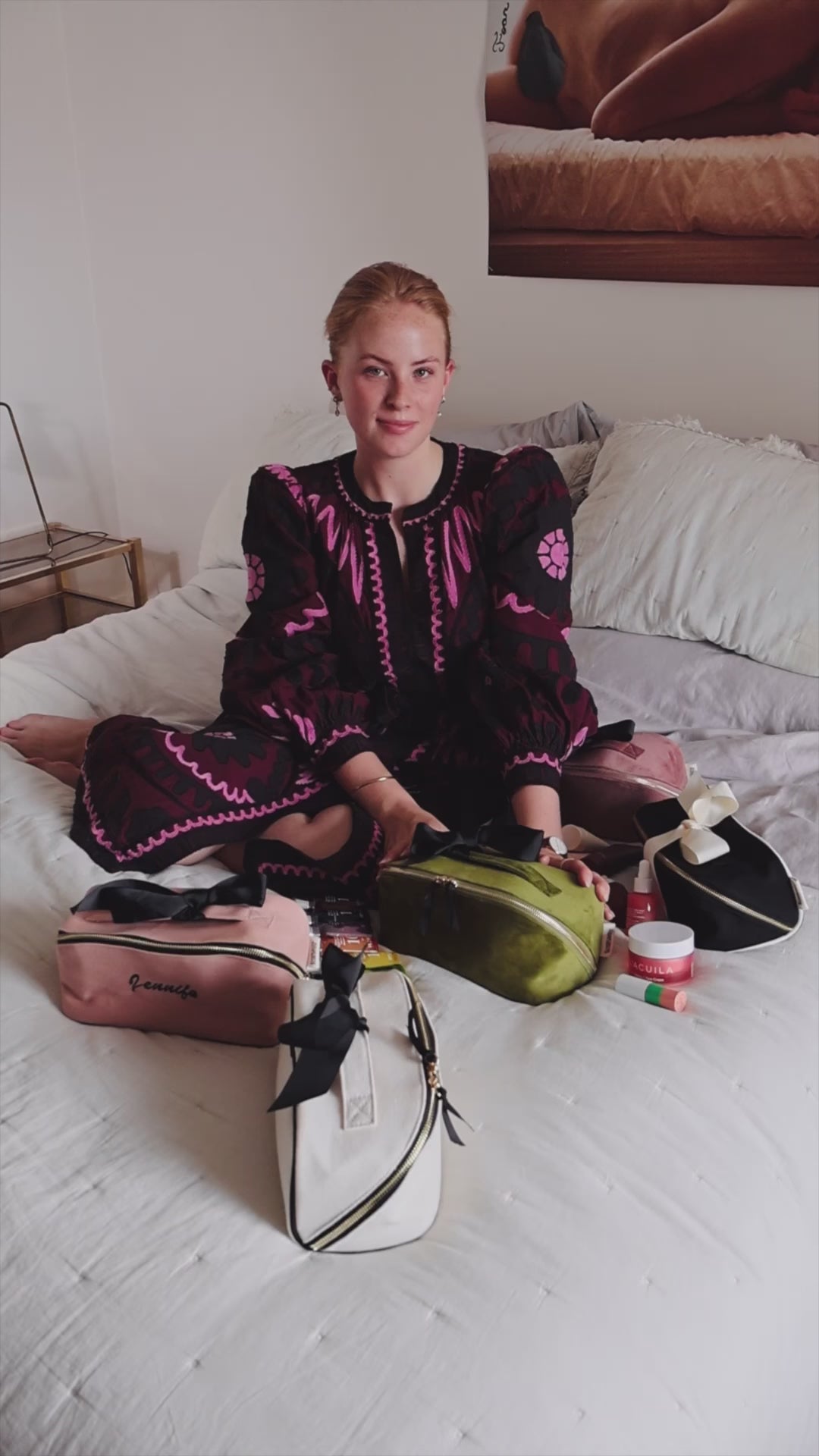 Woman sitting on a bed with Bag-all makeup and toiletry organizers, including the Accordion Box in Green Velvet. Stylish and practical beauty storage