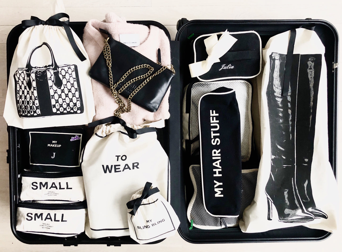 Bag-all Vintage Handbag Travel Bag in cream, featuring organized storage compartments with labeled cotton bags for accessories, boots, and clothing, displayed in sleek black suitcase interior