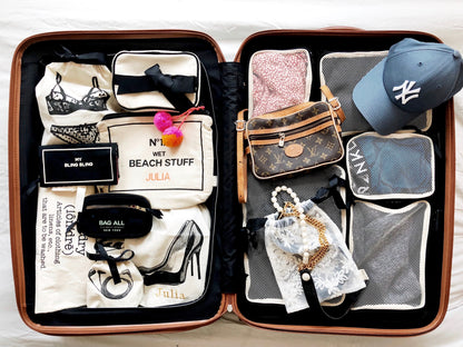 Bag-all Cotton Packing Cubes in black shown organizing travel items in open suitcase with mesh compartments, perfectly sorted clothes and accessories demonstrating space-saving storage