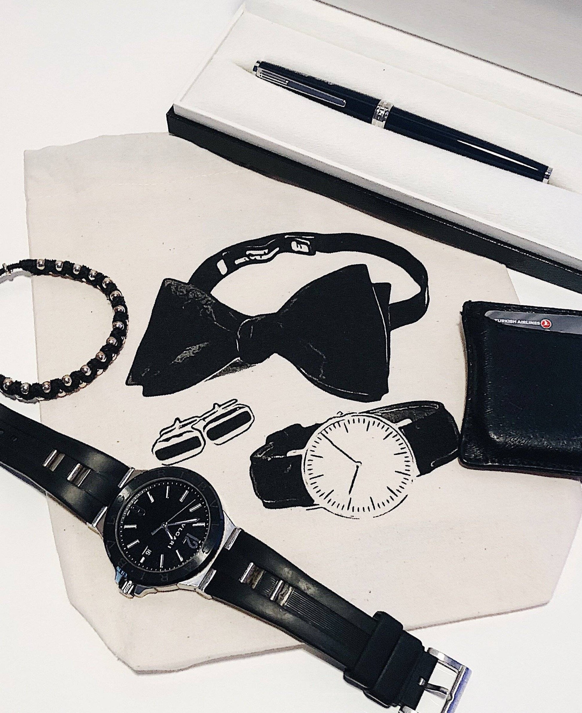 Bag-all Men's Accessories Bag in Cream featuring elegant black accessories including bow tie, watches, cufflinks, bracelet, and pen arranged on cream background, perfect for organizing essentials.