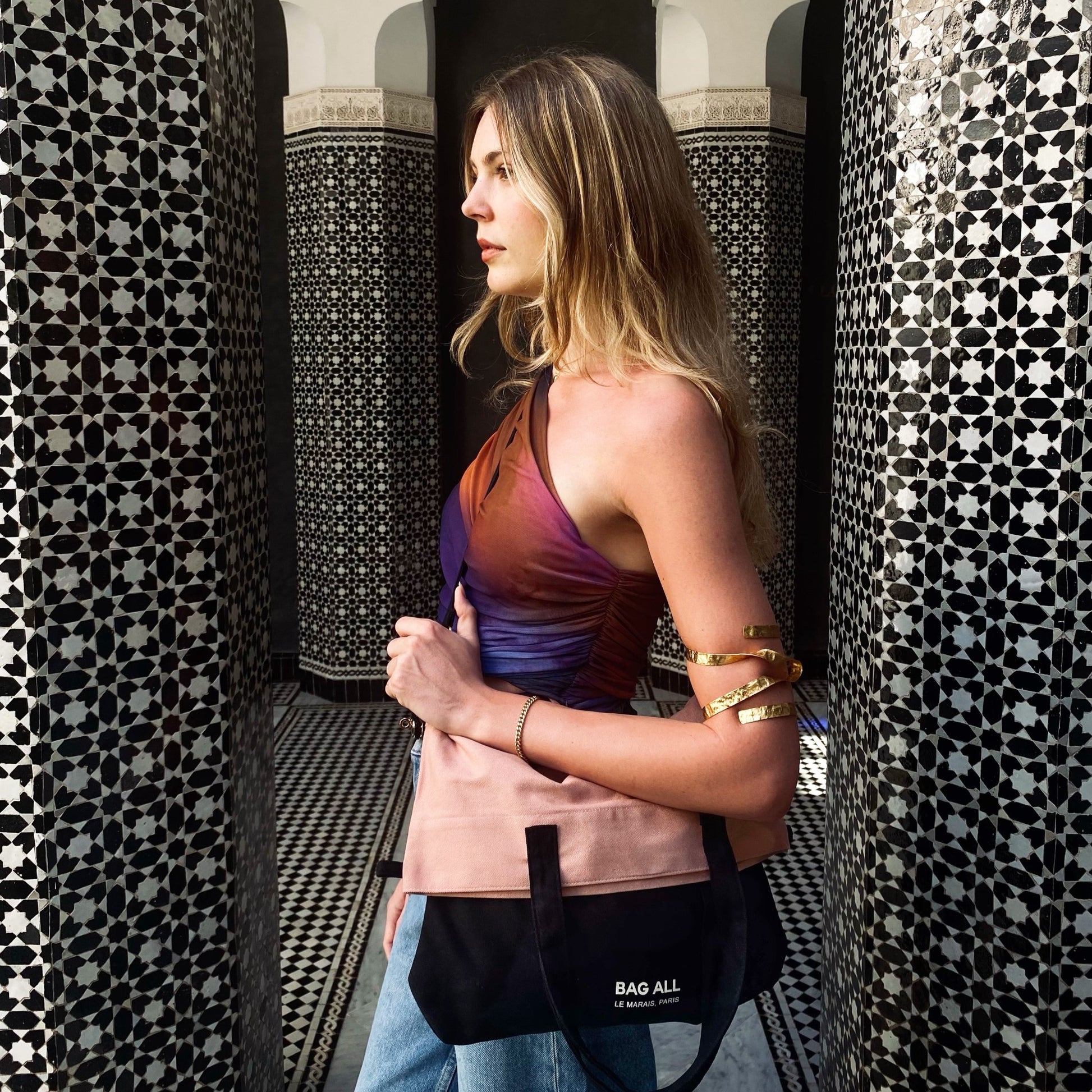 Bag-all black and pink color block crossbody bag styled against ornate Moroccan tiles, showcasing versatile design and urban chic aesthetic