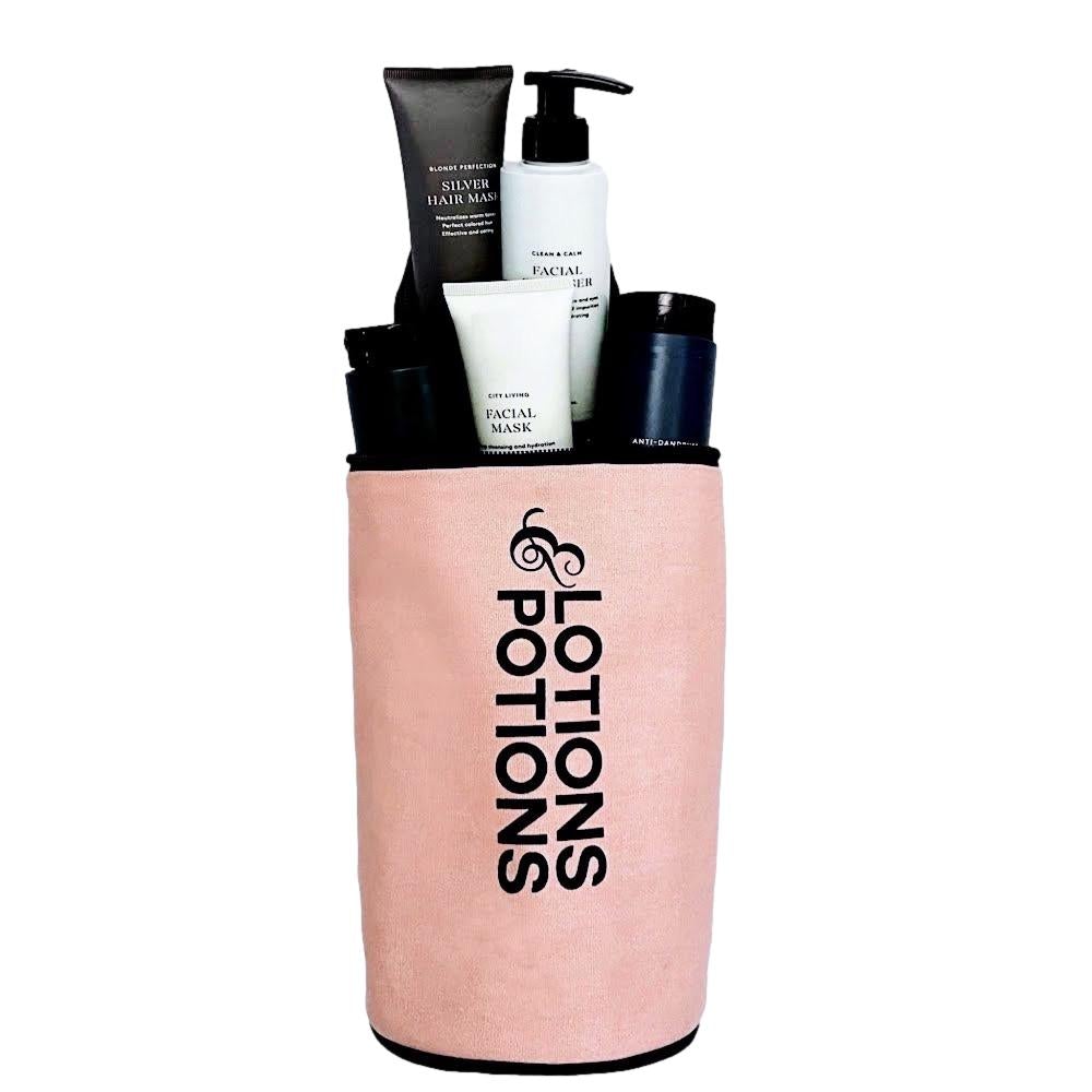 Bag-all Lotions & Potions Travel Case in blush pink with waterproof lining, shown holding various toiletry bottles and skincare products, perfect for organizing bathroom essentials
