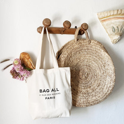 Sac fourre-tout blanc à glissière avec emplacement pour tout sur le devant.