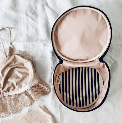 Bag-all Deal Gift Set for Her featuring pink round lingerie case with navy striped interior lining, shown open with delicate lace garment, perfect for elegant storage and organization
