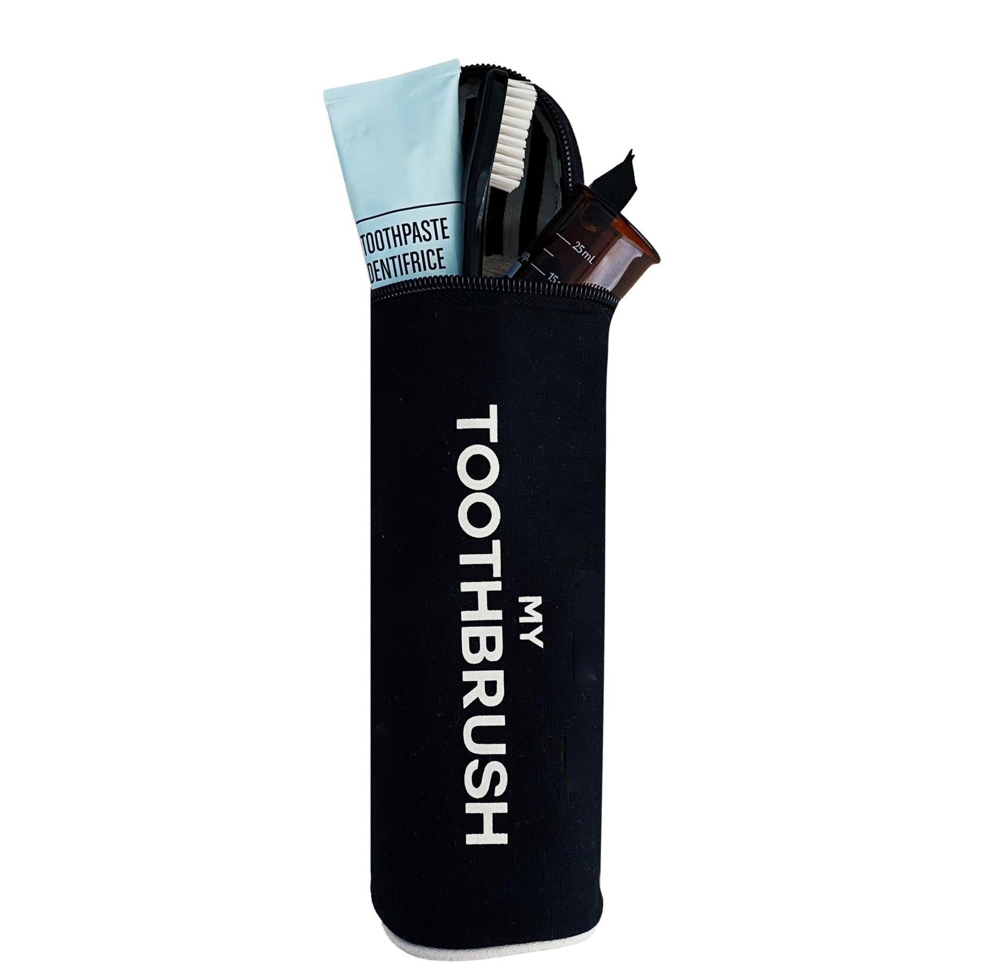 Bag-all black cotton My Toothbrush case with white text, showing toothbrush and toiletry essentials partially visible through open zipper