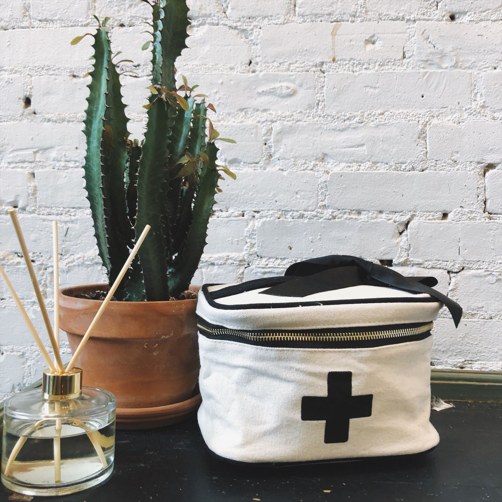 Bag-all Meds and First Aid Storage Box in cream cotton with black cross design, featuring zippered closure and recycled bow - stylish medical storage solution