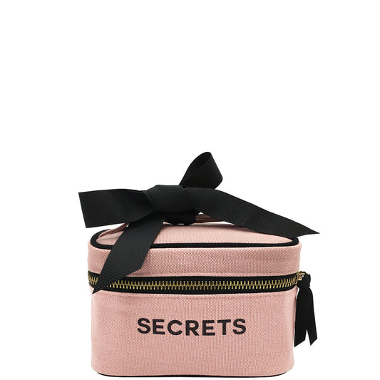 Bag-all Mini Beauty Box for Secrets in blush pink cotton with black bow and zipper, stylish travel-sized cosmetic case featuring laminated interior and convenient handle