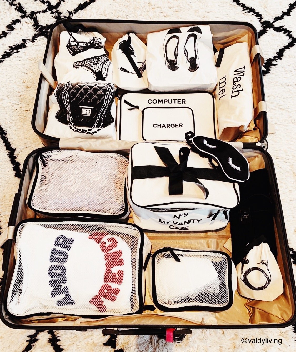 Bag-all Charger Bag in cream shown among organized travel pouches featuring black illustrations, perfect for keeping cords tangle-free and easily accessible in a stylish cotton design